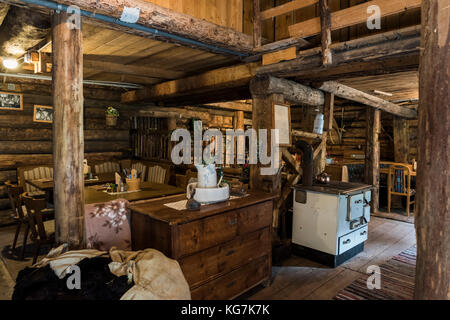 Habachtal, Austria - September 28, 2017: Interior of the old wooden cabin 'Thuringer Hutte' build with thick beams and with old oven, chairs and tabel Stock Photo