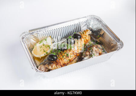 Grilled fish. Healthy food delivery. Take away of natural fitness dishes for diet. Daily meals in foil boxes on the white background. Selective focus Stock Photo