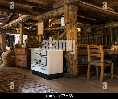 Habachtal, Austria - September 28, 2017: Interior of the old wooden cabin 'Thuringer Hutte' build with thick beams and with old oven, chairs and tabel Stock Photo