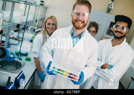 Group of young successful scientists posing for camera Stock Photo