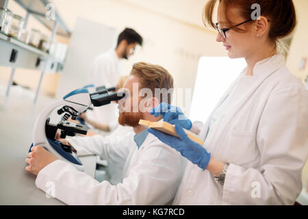 Young scientist looking through microscope in laboratory Stock Photo