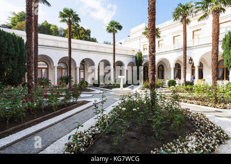 LIVADIYA, CRIMEA - SEPTEMBER 21, 2017: visitors in rose garden in courtyard of Livadia Palace. The palace was the summer residence of the Russian empe Stock Photo
