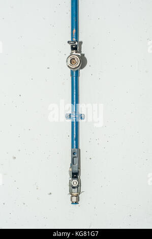 water metal pipe with tap on a white wall Stock Photo