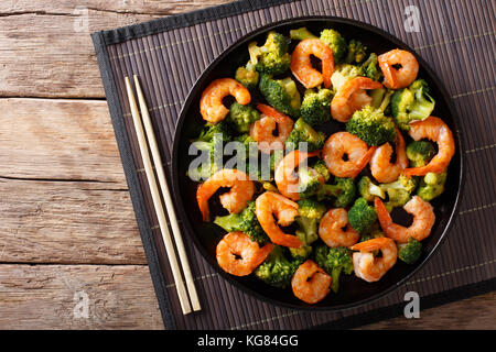 Stir frying shrimp with broccoli closeup on a plate. Horizontal top view from above Stock Photo