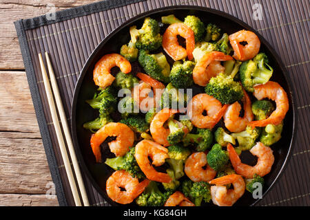 healthy food: stir fry shrimp with broccoli closeup on a plate. horizontal top view from above Stock Photo