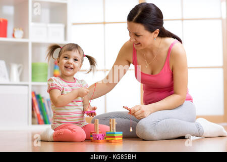 Cute woman and kid girl playing educational toys at home Stock Photo