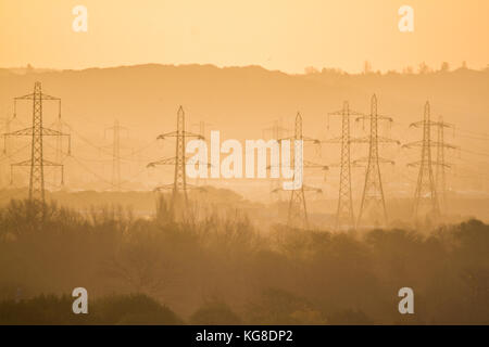 London UK. 5th November 2017. Electricity transmission towers known as pylons are silhouetted against a bright sunrise in Wimbledon on a chilly autumn morning Credit: amer ghazzal/Alamy Live News Stock Photo