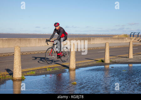 Southport, Merseyside, UK Weather, 5th November, 2017. Sunshine & Showers and blustery westerly winds at the coast, residents take brisk exercise between the heavy showers. Credit. MediaWorldImages/AlamyLiveNews. Stock Photo