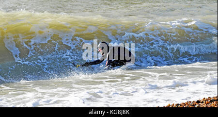 Brighton UK 5th November 2017 - A photographer tries to capture images from inside the waves on a beautiful sunny but cold day in Brighton Stock Photo