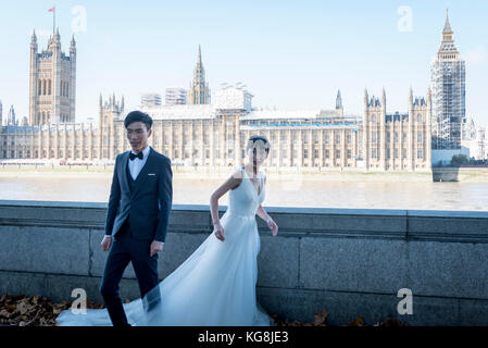 London, UK.  5 November 2017.  A mainland Chinese couple has pre-wedding photographs taken on Westminster Bridge.  With Sterling's decline, London is seen as an ever more affordable location for such photographs, as well as providing landmarks as backdrops.  Frequently, the photographer and team are also flown out from China to capture the images.  Credit: Stephen Chung / Alamy Live News Stock Photo