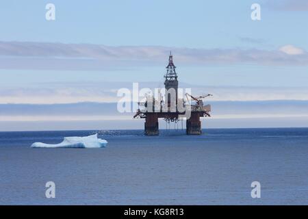 An Iceberg floating by an oil rig, Bay Bulls, Newfoundland and Labrador, Canada Stock Photo