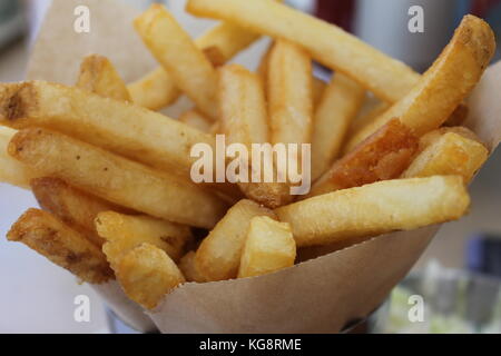 Fresh cut french fries in a brown paper cone Stock Photo