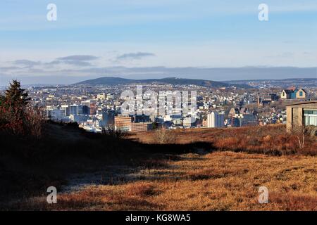 Looking out over the city of St. John's from Signal Hill, St. John's, Newfoundland Labrador, Canada. Grassy field with frost in foreground. Stock Photo