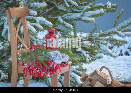 Scandinavian style wool mittens on the Christmas plaid near firewood. Toned. Stock Photo