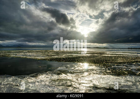 Winter Landscape frozen lake with ice floes and cloudy sky in Ic