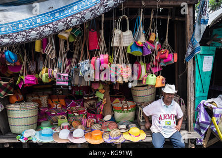 A Malagasy man sit in front of his stall selling souvenirs and local products in a market. Madagascar, Africa. Stock Photo