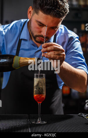 Bartender preparing a champagne cocktail with rose jam Stock Photo