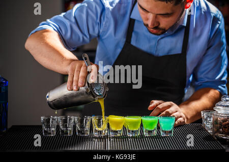 Barman is preparing Rainbow color shots Stock Photo
