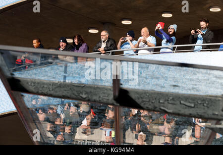 Fans wait for the teams to arrive before the Premier League match at the Etihad Stadium, Manchester. Stock Photo