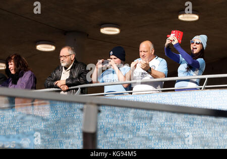 Fans wait for the teams to arrive before the Premier League match at the Etihad Stadium, Manchester. Stock Photo