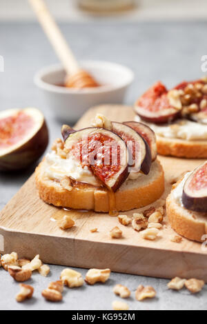 sandwiches with figs, ricotta, honey and walnuts on a gray background Stock Photo