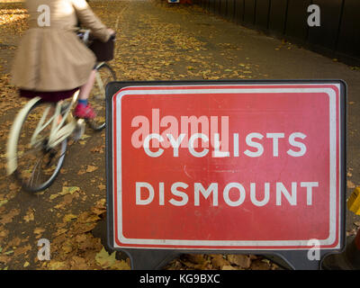 A cyclist ignores a sign ordering that the bicycle must be dismounted Stock Photo