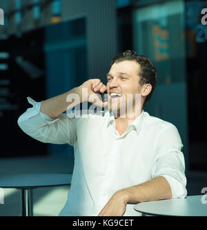 Portrait of a handsome businessman enjoy talking on mobile phone sitting in cafe Stock Photo