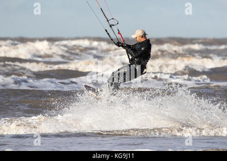 Southport, Merseyside, Kite Surfer. 5th November 2017. UK Weather.  On a bright but blustery day over the north west coastline, a kite surfer rips some waves on the incoming tide along the shores of Southport beach in Merseyside.  Credit: Cernan Elias/Alamy Live News Stock Photo