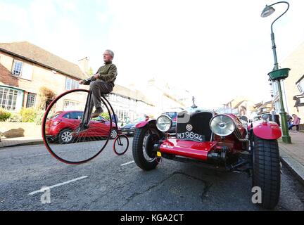 A man on a penny Farthing rides down Cuckfield high street during the London to Brighton Veteran Car Run. 05 Nov 2017 Stock Photo