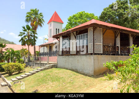 Side view of Deshaies church and surrounding buildings, used as set of English BBC tv movie Death in Paradise Stock Photo