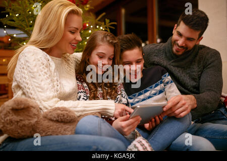 Family having fun while looking Christmas photos Stock Photo