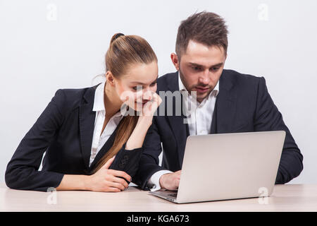 man and woman sitting in a business suit at a table in front of  Stock Photo
