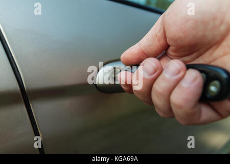 man's hand opens the car door with a key. Stock Photo