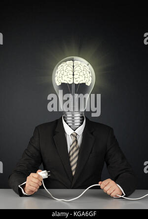 Businessman with light bulb head and plug, switch brain creative concept on black Stock Photo