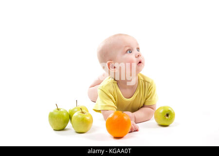 cute smiling baby lying on his stomach among fruits and looking  Stock Photo