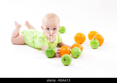 baby lying on the background and smiling among fruit Stock Photo