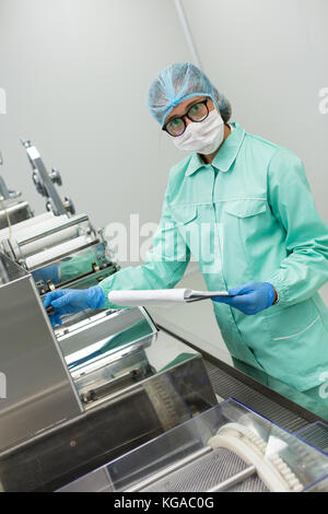 scientist is making notes of machine Stock Photo