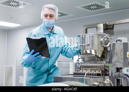 scientist making notes about machine Stock Photo