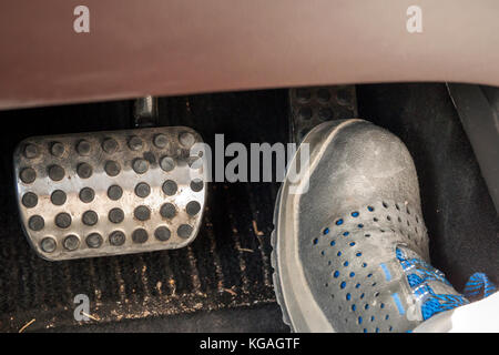 Foot in a work boot pressing acseleration in car Stock Photo