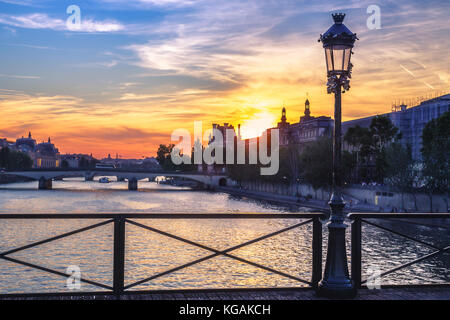 Colourful sunset over Paris, France, seen from Pont des Arts. Romantic cityscape with dramatic sky. Popular travel destination. Stock Photo