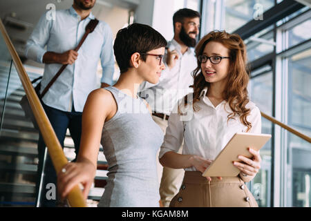 Portrait of two young attractive businesswomen talking on break Stock Photo