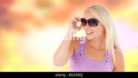 Digital composite of Woman with sunglasses and sun warm background Stock Photo