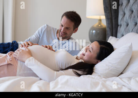 Couple feeling the presence of baby in stomach at home Stock Photo