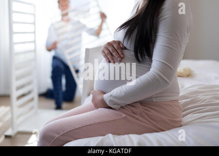 Mid section of woman feeling the presence of baby in stomach Stock Photo