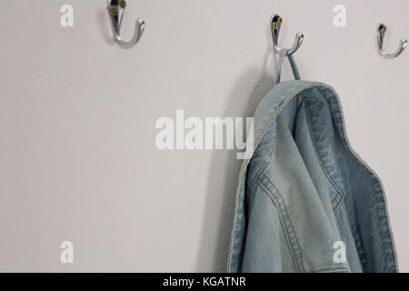 Close-up of denim jacket hanging on hook Stock Photo