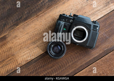 old film DSLR camera with lens on a wooden table.photography concept Stock Photo