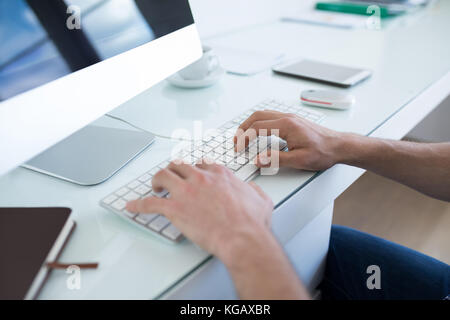 Mid section of man working on personal computer Stock Photo
