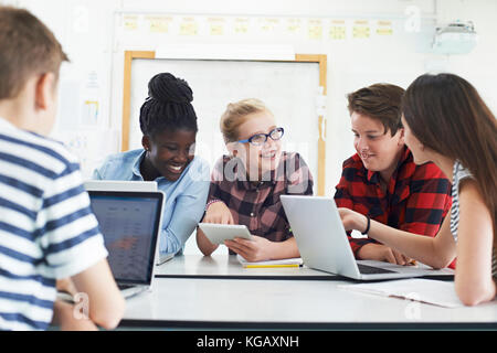 Group Of Teenage Students Collaborating On Project In IT Class Stock Photo