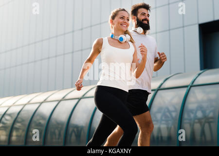 Young fitness couple running in urban area Stock Photo