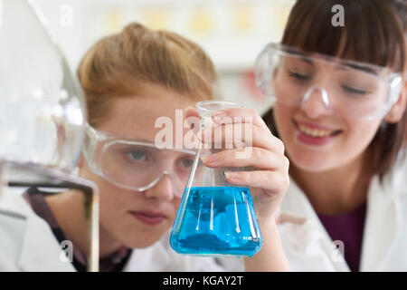 Female Pupil And Teacher Conducting Chemistry Experiment Stock Photo